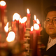 Harvey Guillén as Guillermo, standing beside a bunch of candles.
